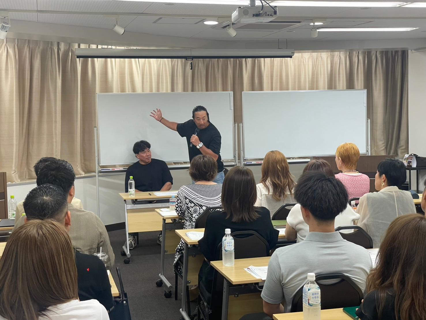 講習会で身振りを交えて講義する講師